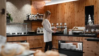 Frau im Wellnessbereich des Holzleiten Bio Hotels mit Spa- und Saunaauswahl.