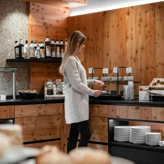 Frau im Wellnessbereich des Holzleiten Bio Hotels mit Spa- und Saunaauswahl.